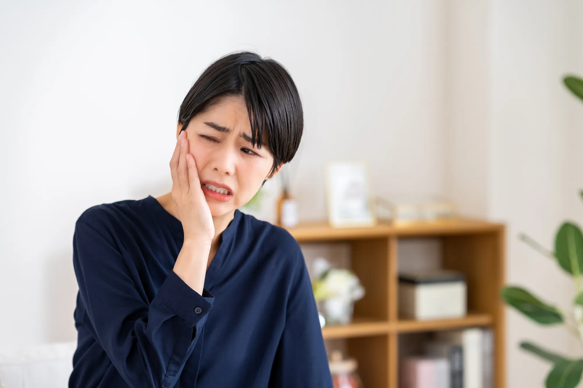 知覚過敏またはむし歯で歯が痛む女性