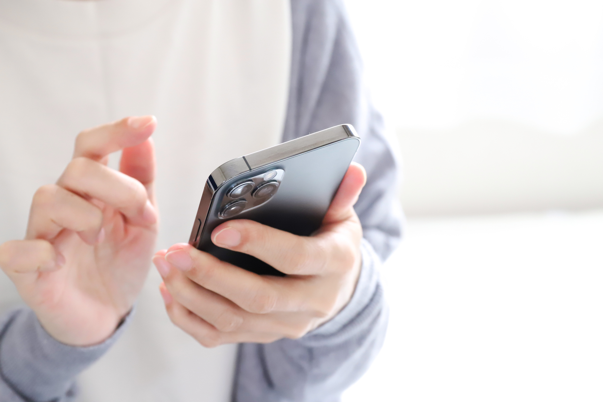 スマートフォンで歯医者の予約をしている女性